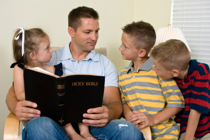 father reading Bible
                          to his children